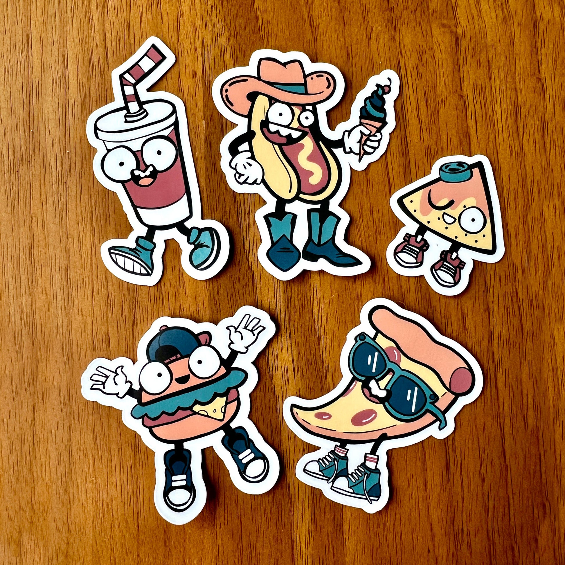 Five cartoon-style food stickers on a wooden surface